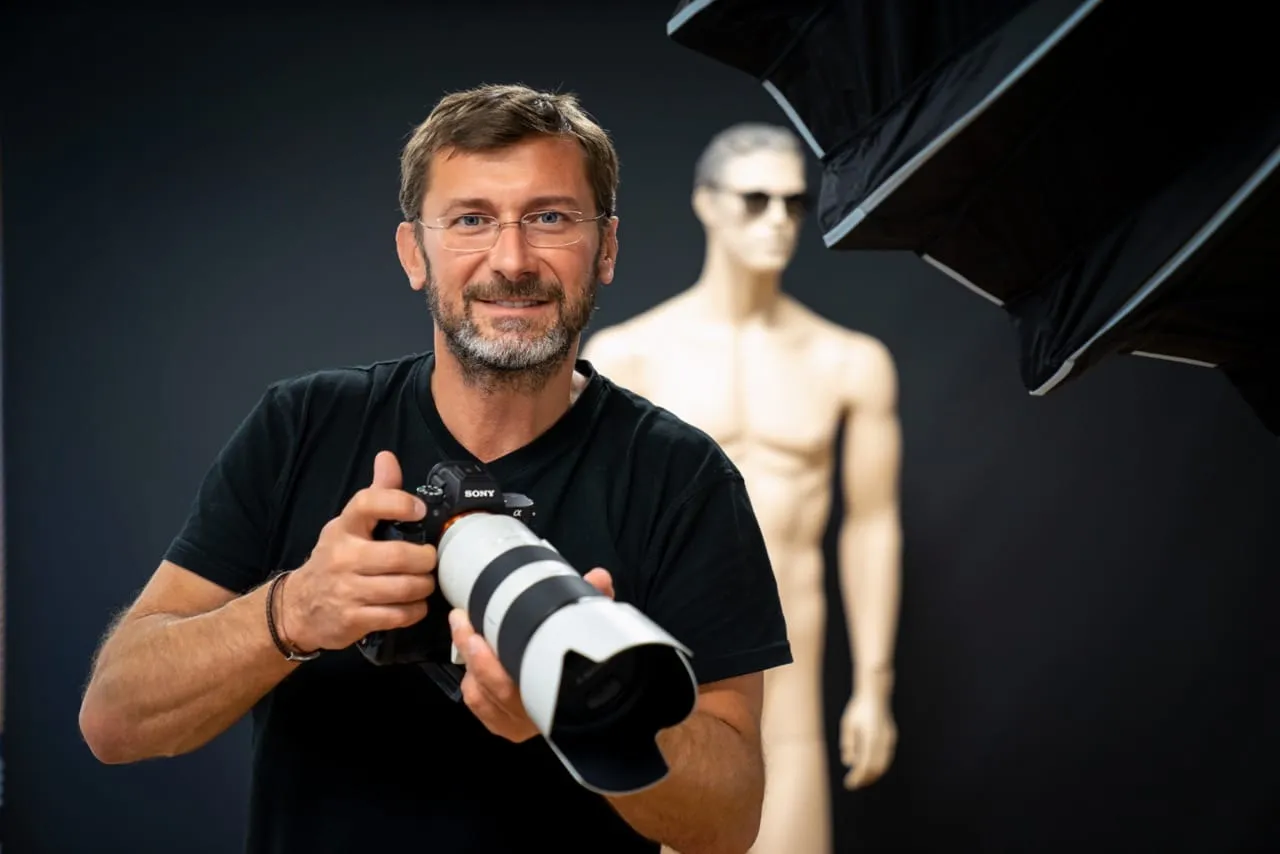 Christian Freydl mit einer Kamera in seinem Fotostudio